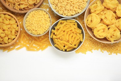 Photo of Different types of pasta on white background, flat lay. Space for text