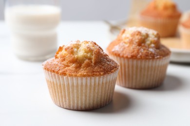 Photo of Delicious sweet muffins on white table, closeup