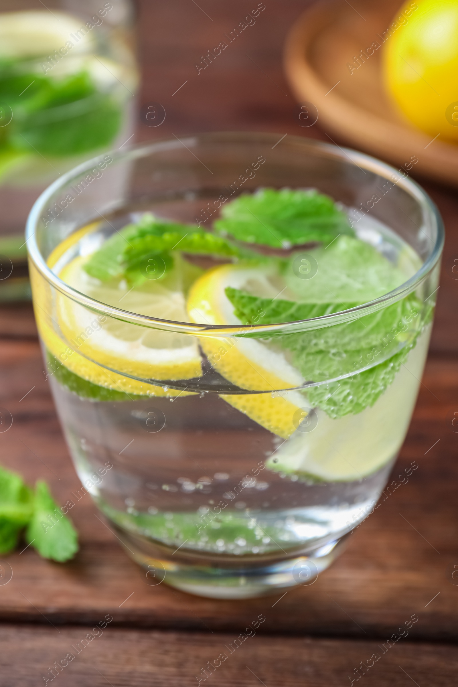 Photo of Tasty refreshing lemonade on wooden table, closeup. Summer drink