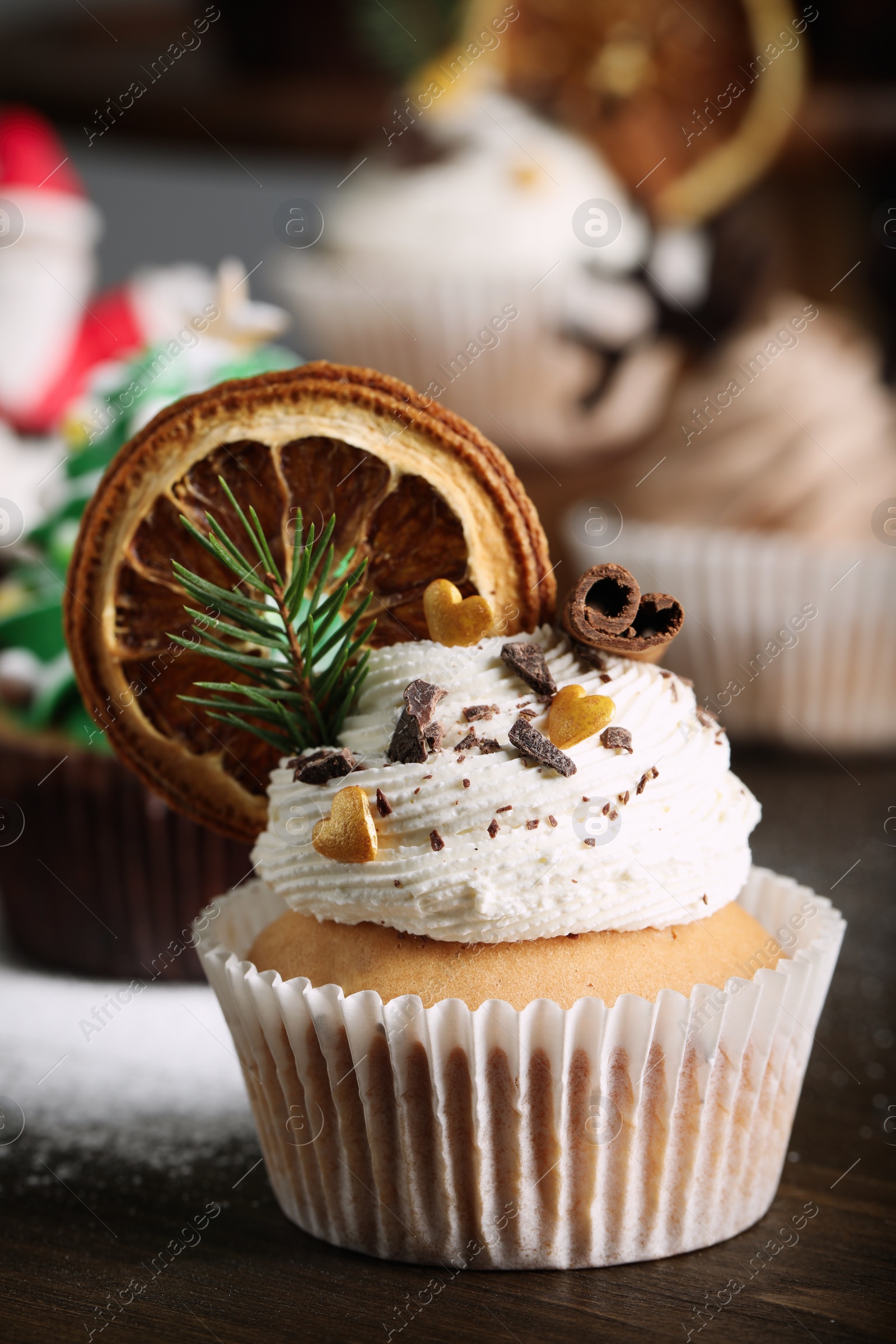 Photo of Beautifully decorated Christmas cupcake on wooden table, closeup