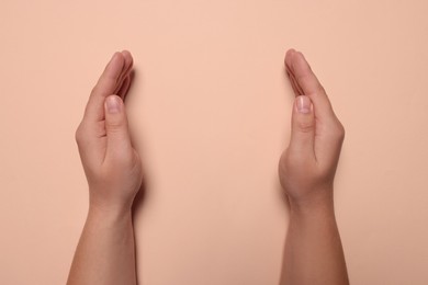 Photo of Woman holding on pale pink background, closeup of hands. Space for text