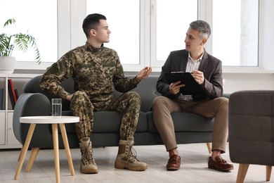 Professional psychotherapist working with military man in office