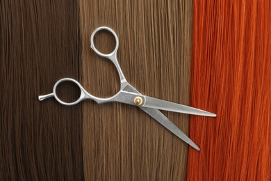 Photo of Scissors on hair, top view. Hairdresser service