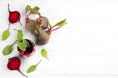 Photo of Fresh beet juice and raw vegetable on white wooden background, flat lay. Space for text