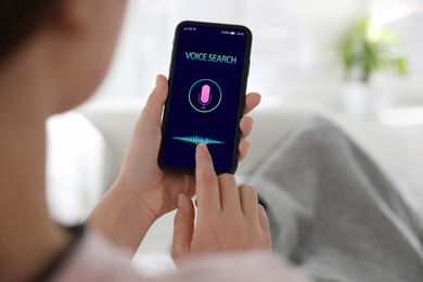 Image of Woman using voice search on smartphone indoors, closeup