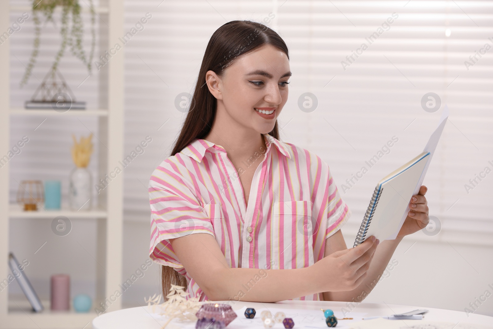 Photo of Astrologer making forecast of fate at table indoors. Fortune telling