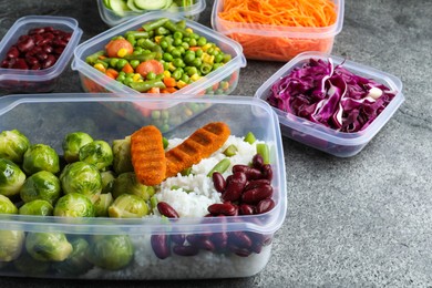 Photo of Set of plastic containers with fresh food on grey   table