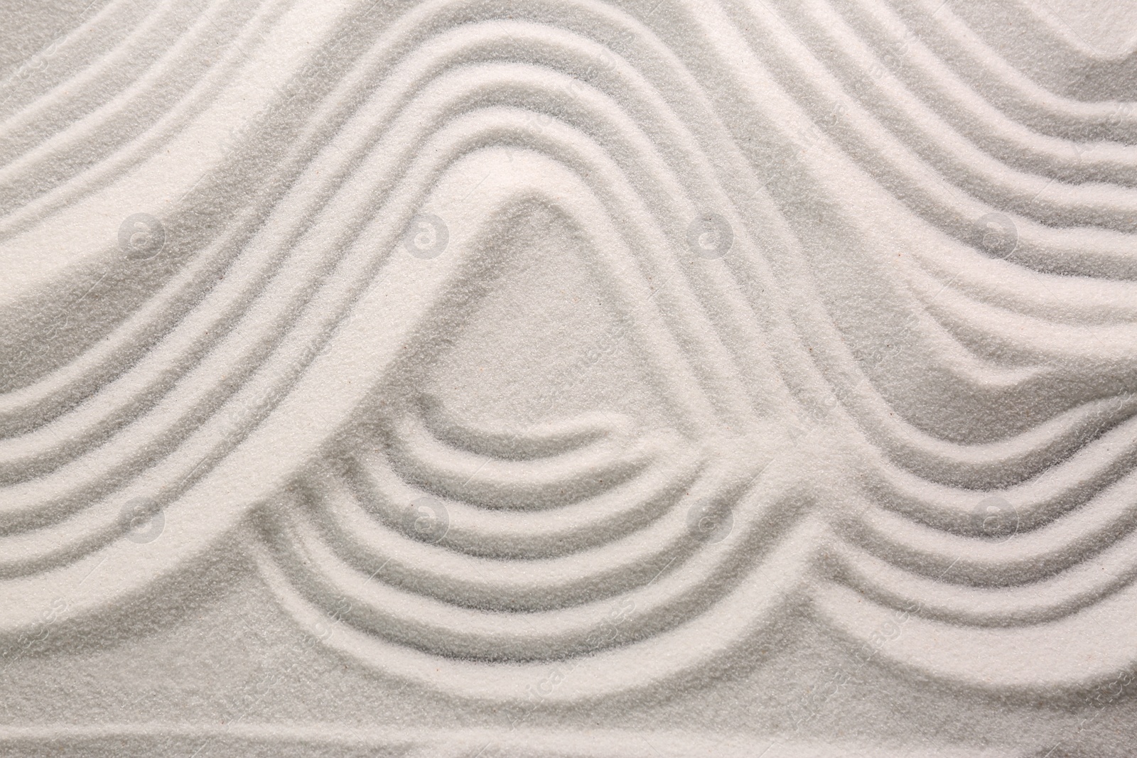 Photo of White sand with pattern as background, top view. Concept of zen and harmony