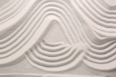 Photo of White sand with pattern as background, top view. Concept of zen and harmony