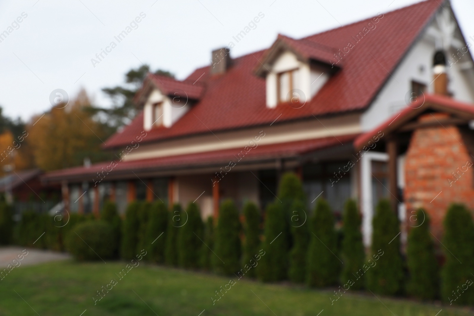 Photo of Blurred view of beautiful house with red roof outdoors. Real estate