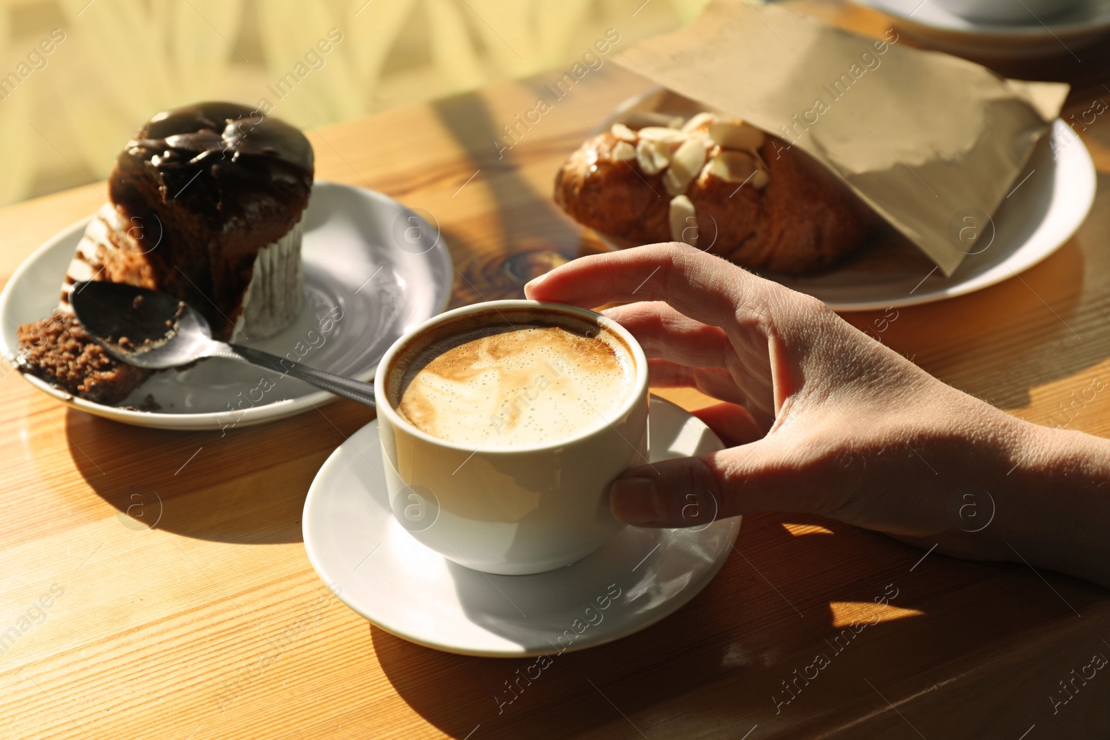 Photo of Woman with cup of fresh aromatic coffee at table in cafe