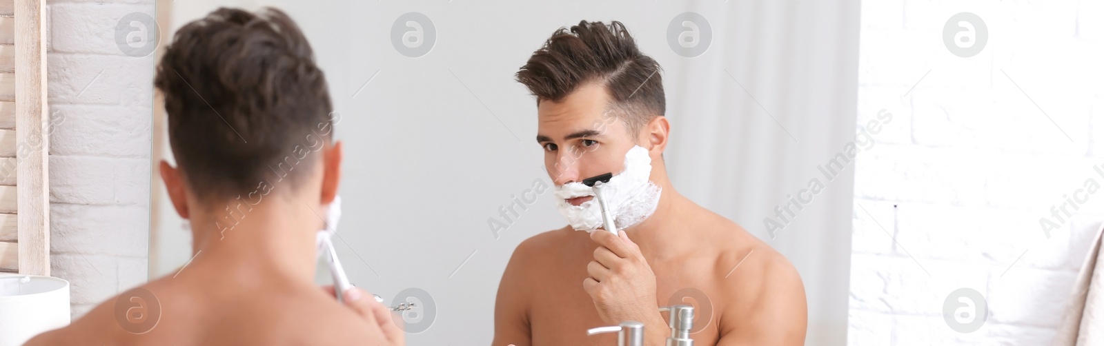 Image of Young man shaving near mirror in bathroom. Banner design