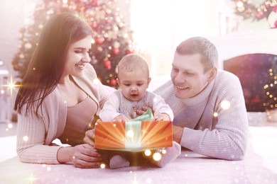 Image of Happy family with cute baby on floor in room decorated for Christmas. Magical festive atmosphere