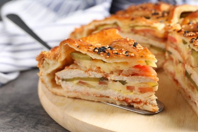 Photo of Cut delicious homemade pie and server on grey table, closeup