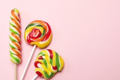 Sweet lollipops on pink background, flat lay. Space for text