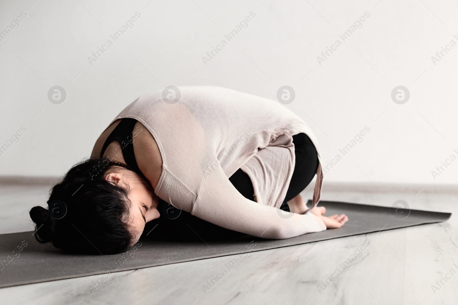 Photo of Sporty woman practicing yoga indoors