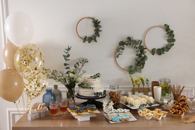 Photo of Beautiful cake and other treats on table in room. Baby shower party