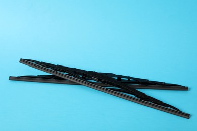 Photo of Car windshield wipers on light blue background. Space for text