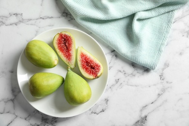 Photo of Plate with fresh ripe figs on marble background, top view