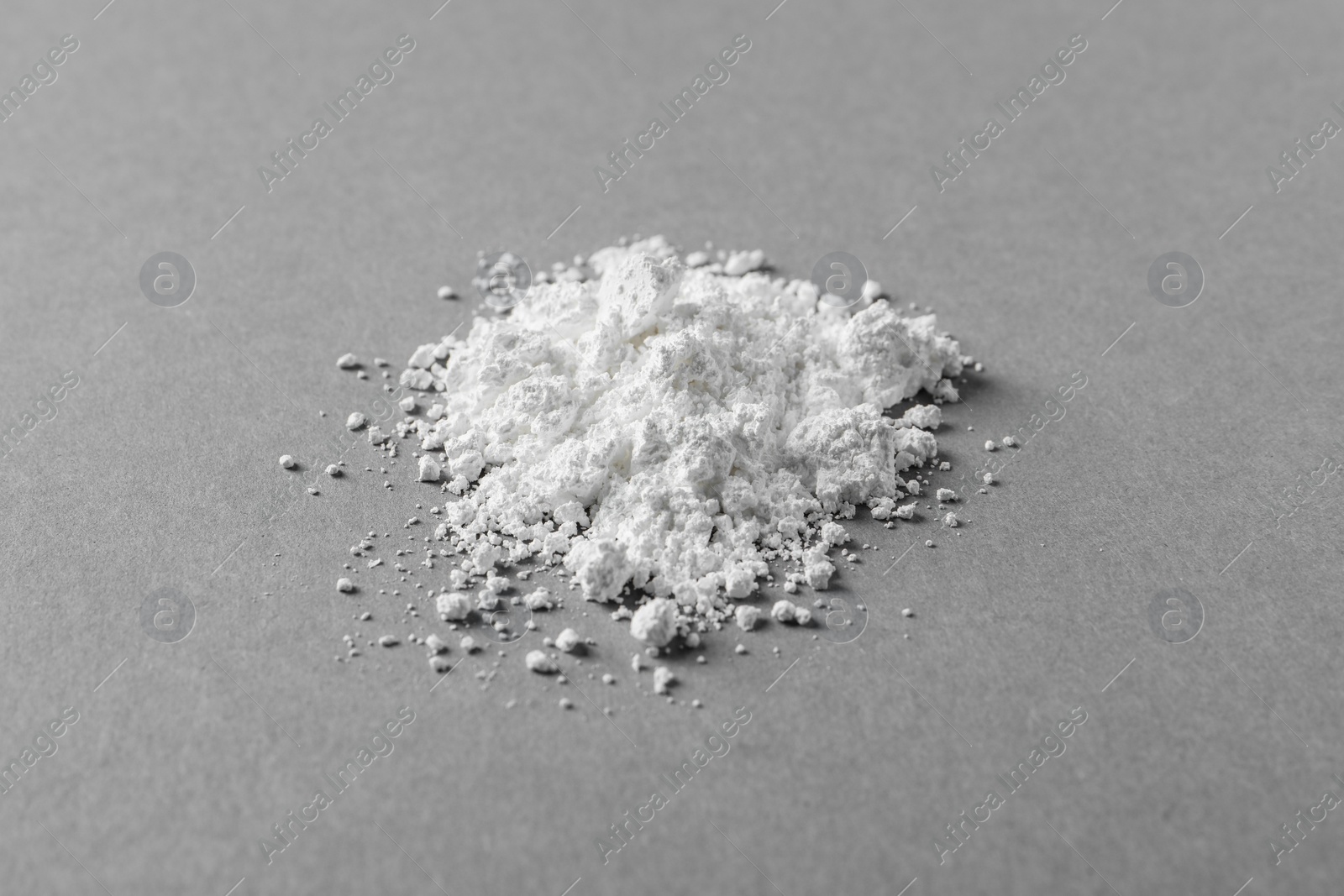 Photo of Heap of calcium carbonate powder on grey table