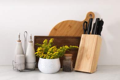 Photo of Wooden kitchenware and mimosa flowers on countertop indoors