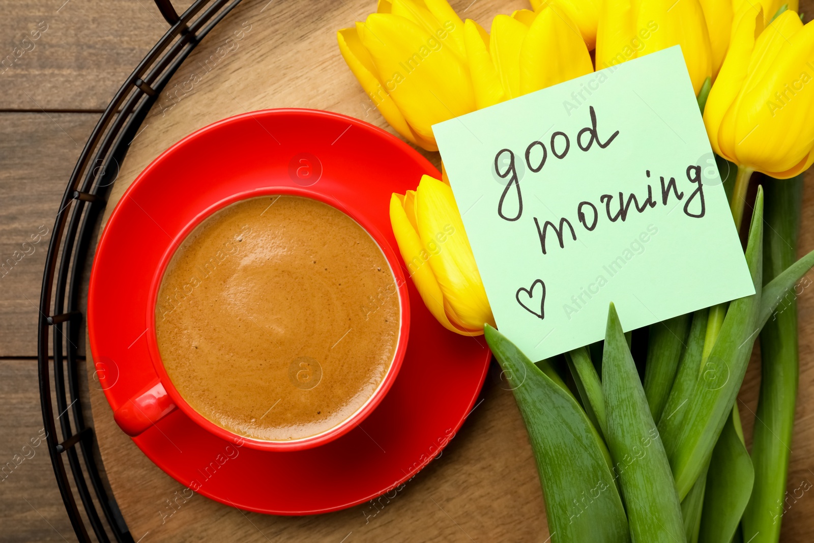 Photo of Tray with beautiful yellow tulips, cup of aromatic coffee and Good Morning note on wooden table, top view