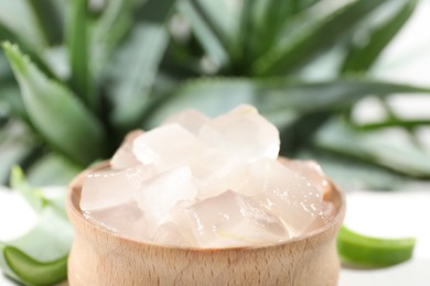 Photo of Aloe vera gel in bowl on blurred background, closeup