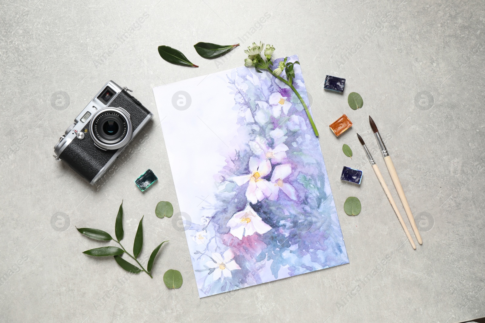 Photo of Flat lay composition with watercolor paints and floral picture on grey stone table