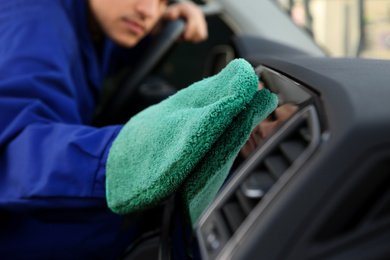 Photo of Car wash worker cleaning automobile interior, closeup