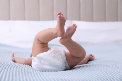 Photo of Little baby in diaper on bed, closeup