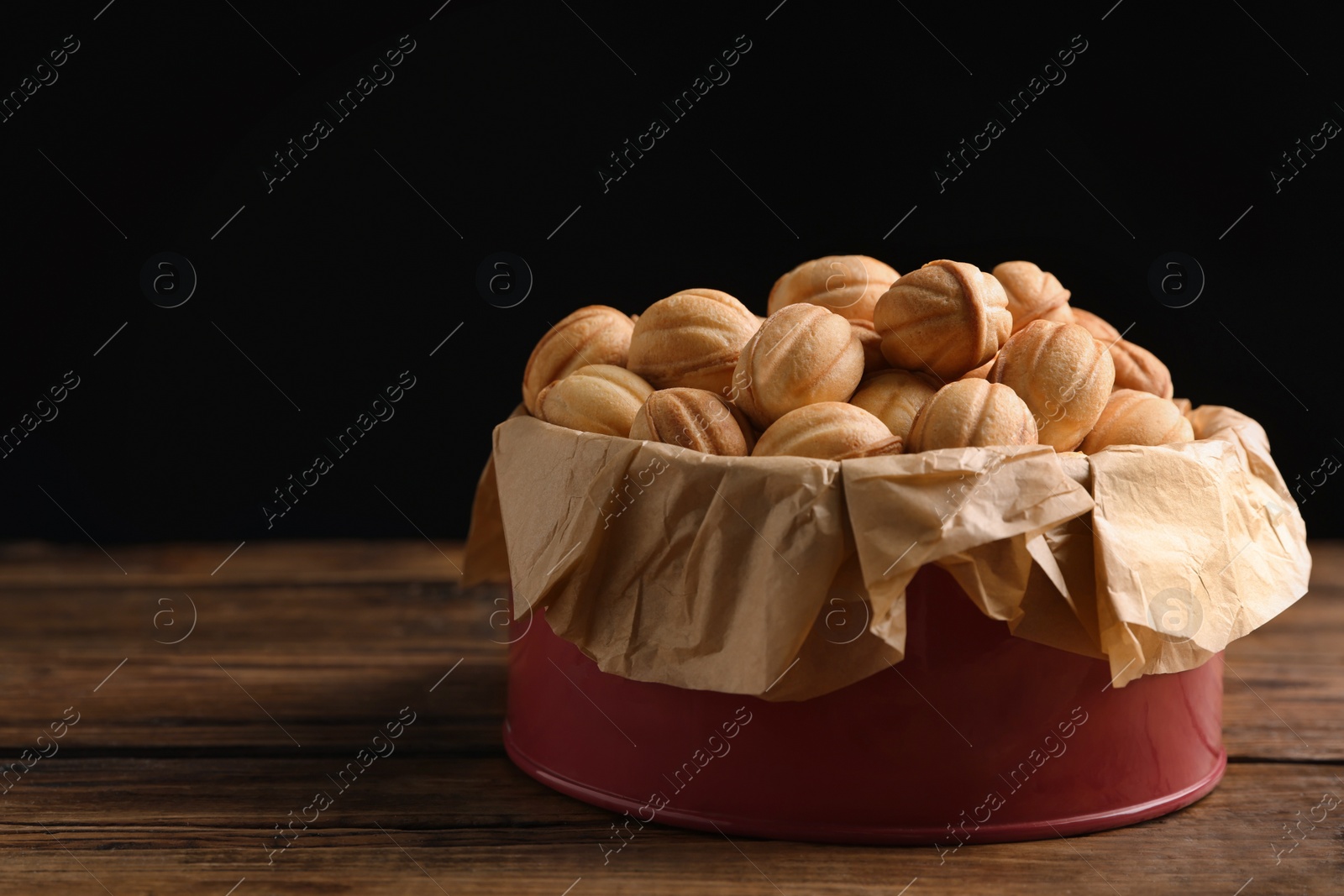 Photo of Homemade walnut shaped cookies with boiled condensed milk on wooden table. Space for text