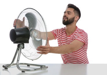 Man enjoying air flow from fan on white background. Summer heat