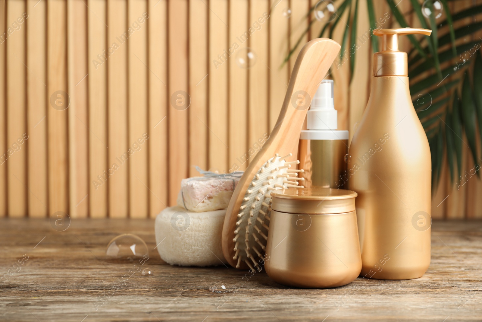 Photo of Composition with hair care cosmetic products on wooden table. Space for text