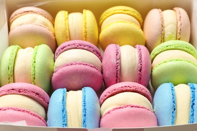 Many delicious colorful macarons in box, closeup