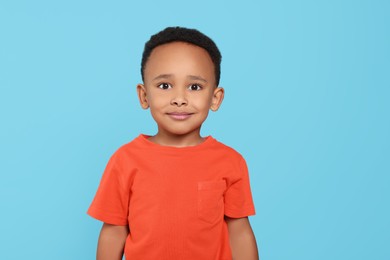 Photo of Portrait of cute African-American boy on turquoise background