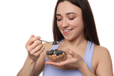 Happy woman eating tasty granola with fresh berries on white background