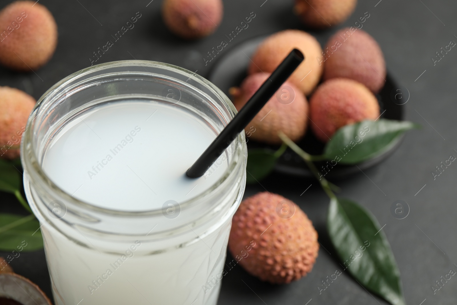 Photo of Freshly made lychee juice on grey table, closeup. Space for text