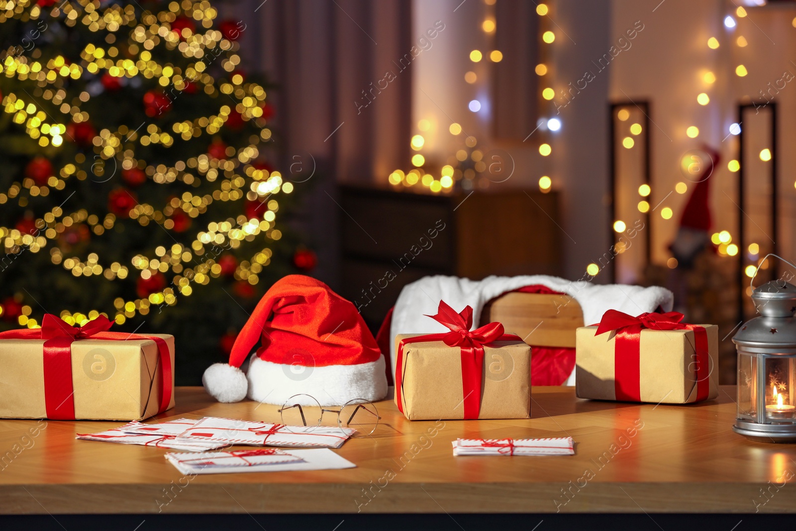 Photo of Santa's Claus workplace. Gift boxes, letters on table and costume in room with Christmas decor