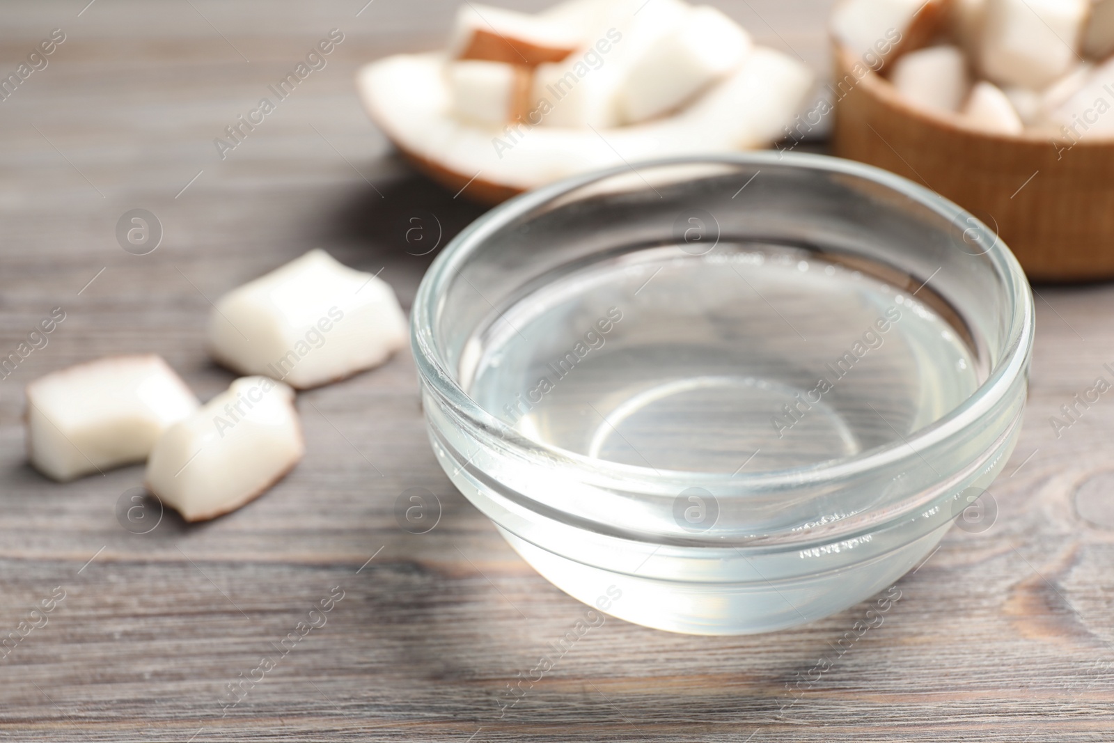 Photo of Coconut oil on wooden table, closeup view