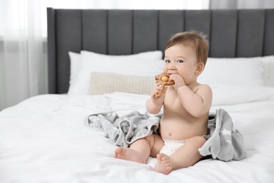 Photo of Cute baby boy with blanket and rattle sitting on bed at home. Space for text