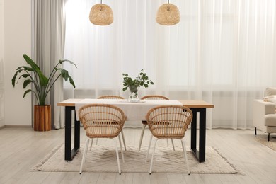 Photo of Stylish dining room with cozy furniture and plants