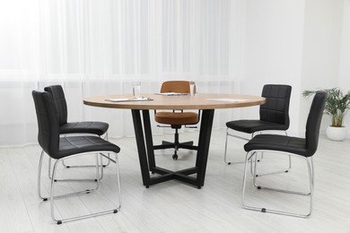 Photo of Empty conference room with wooden table and chairs