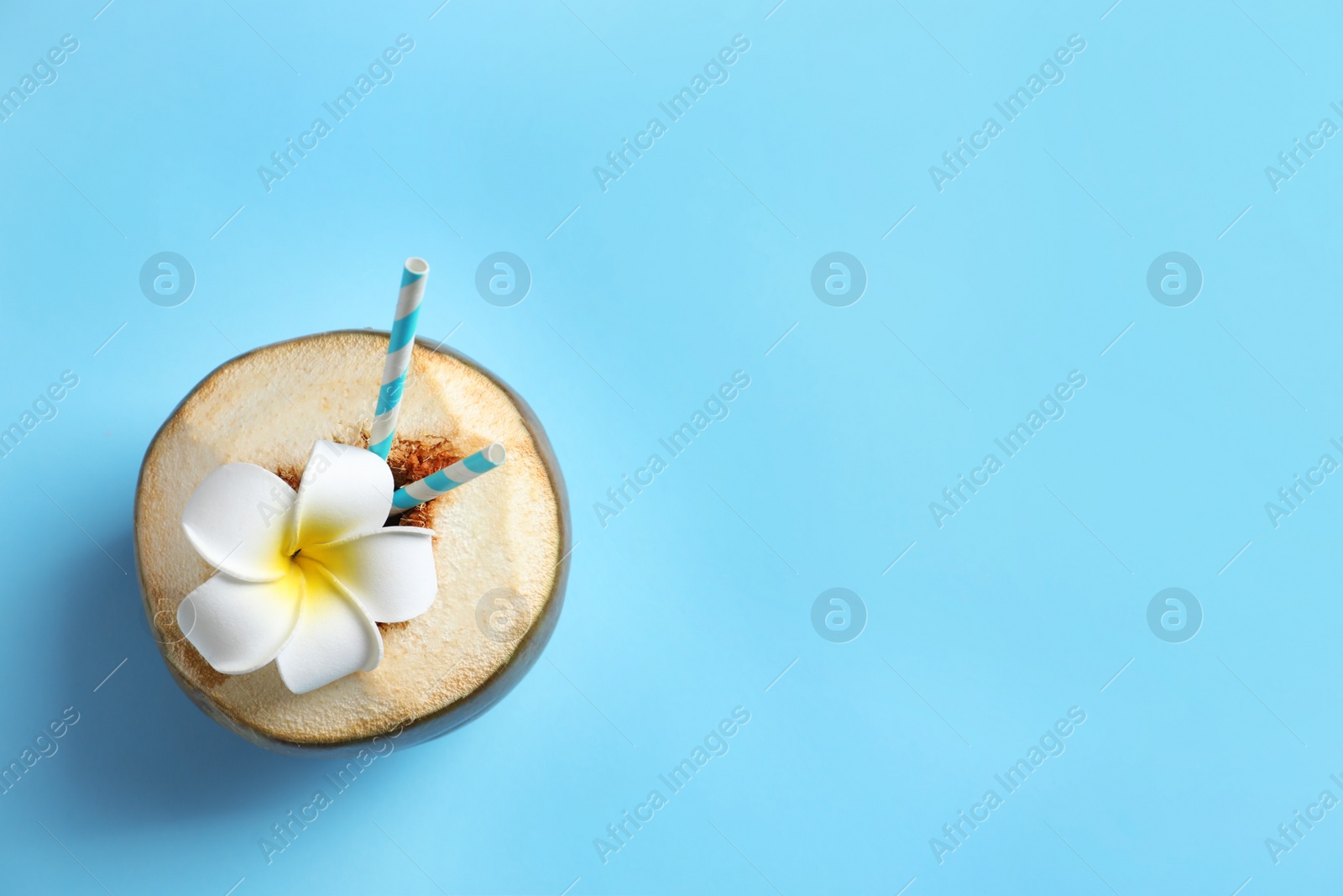 Photo of Fresh green coconut with drinking straws and flower on color background