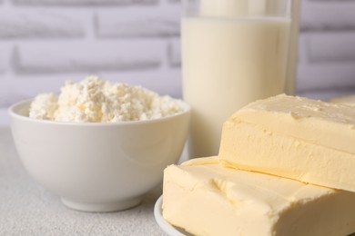 Photo of Tasty homemade butter and dairy products on white textured table, closeup