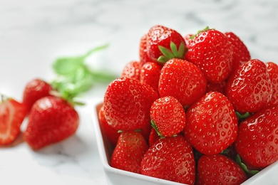 Photo of Bowl with ripe strawberries on light background, closeup