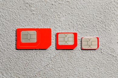 Photo of Different SIM cards on stone background, flat lay