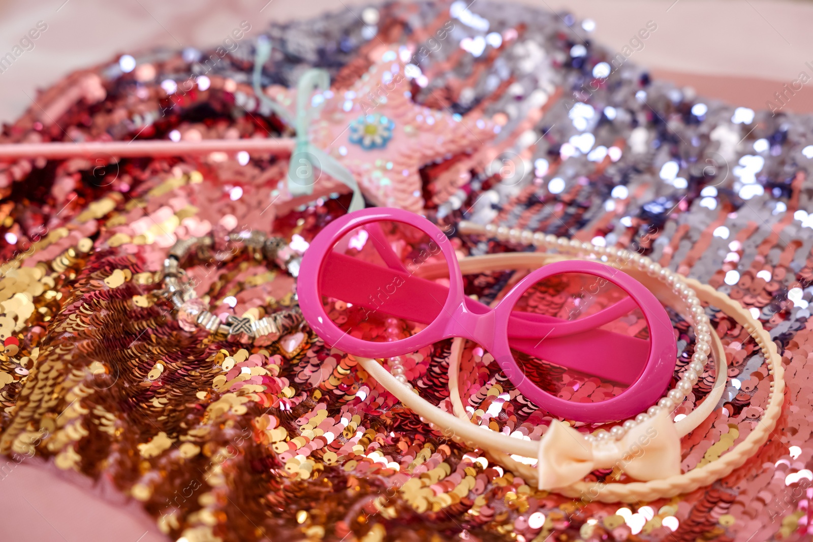 Photo of Stylish carnival costume with sequins, sunglasses, wand and headbands, closeup