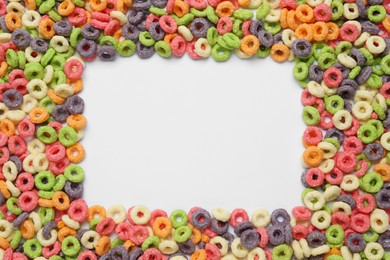 Photo of Frame of sweet tasty colorful corn rings on white background, top view. Space for text