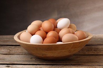 Fresh chicken eggs in bowl on wooden table