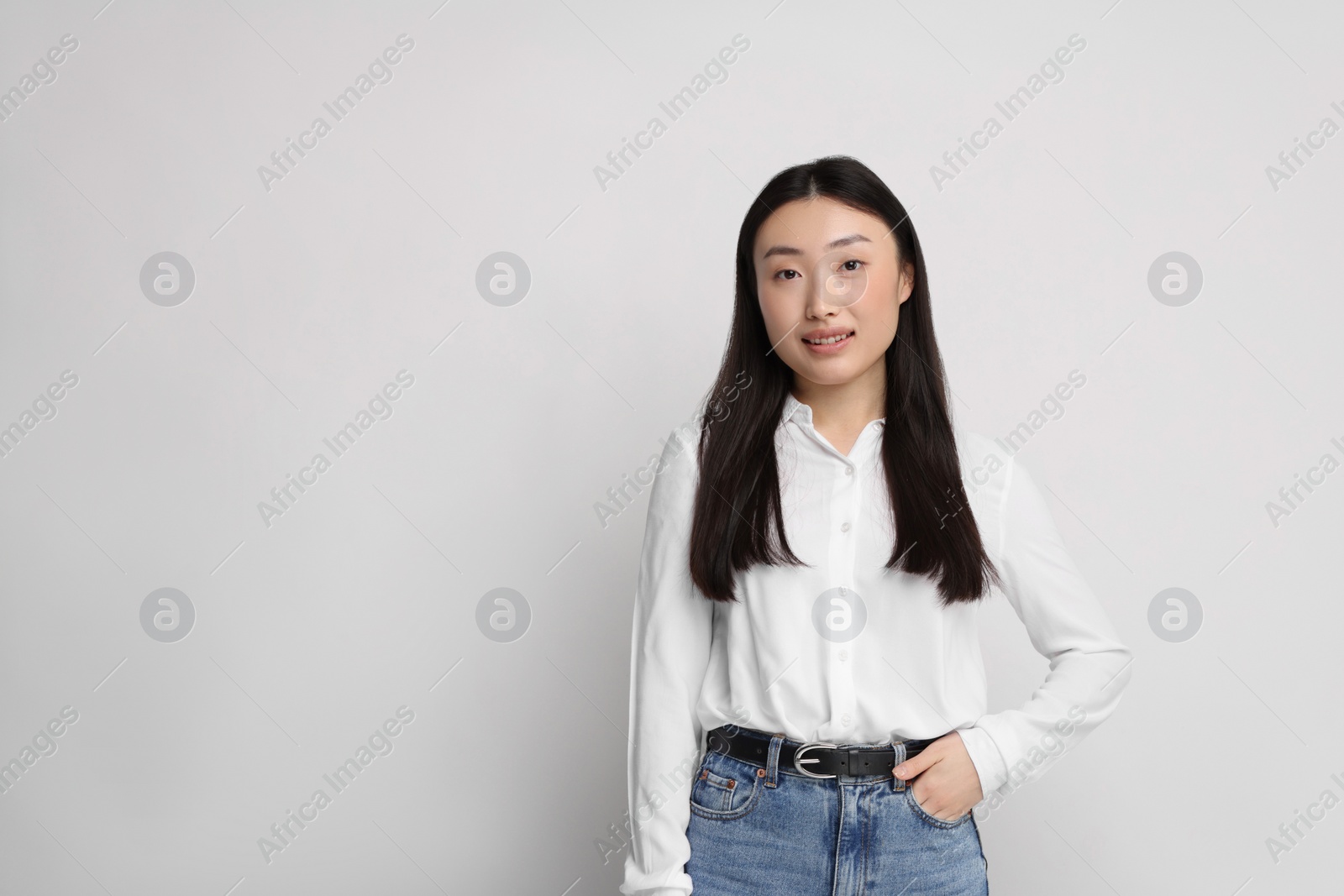 Photo of Portrait of smiling woman on light background. Space for text